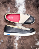 Two black and white shoes on a textured brown surface