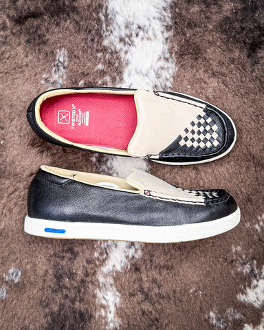 Two black and white shoes on a textured brown surface