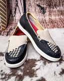Black and white checkered loafers on a textured surface