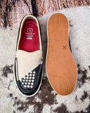 White slip-on shoe with checkered pattern and red interior, displayed on a textured surface.