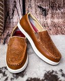 Brown loafers with white soles on a textured surface