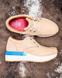 Beige casual shoes with white soles on a textured brown surface