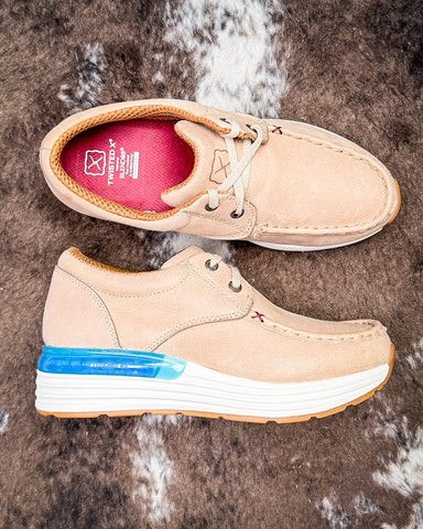 Beige casual shoes with white soles on a textured brown surface