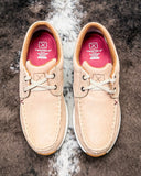 Pair of beige shoes with tan laces on a textured brown background