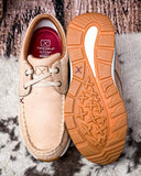Beige shoe with brown sole on a textured surface