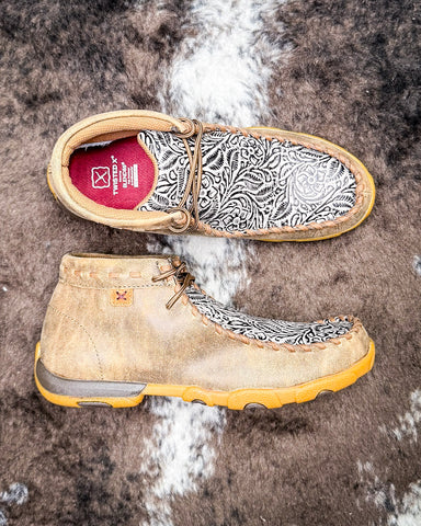 Pair of beige and brown shoes with white pattern on a textured surface