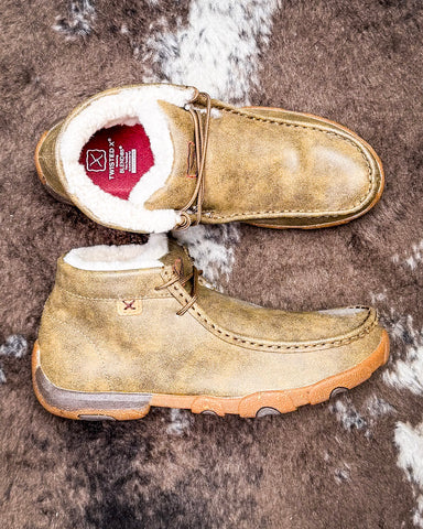 Twisted X shearling lined mocs on a textured surface.