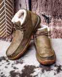 Pair of brown leather shoes with white fur lining on a textured surface.