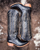 Pair of black cowboy boots with intricate copper embroidery on a textured surface