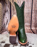 Green cowboy boot with tan insole on a wooden background