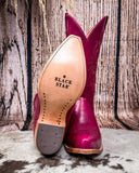 Western boots displaying on cowhide rug, one tilt over to see the rubber bottom 