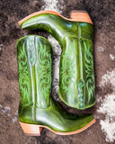 Green cowboy boots with intricate designs on a textured surface