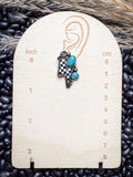 Single earring on wooden size guide.



