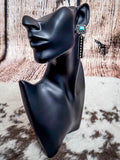 Silver bar and turquoise stud earring shown on mannequin display.