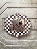 Silver Western buckle with aces, dice, and checkerboard background, shown with ruler for size.