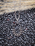 Boho Western teardrop pendant necklace with silver beads styled on black beans and pampas