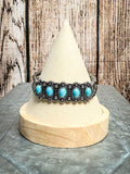 Vintage-style turquoise row cuff bracelet with floral silver accents – Navajo-inspired