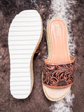 Top and sole view of brown tooled leather slide sandals with white ribbed rubber sole.
