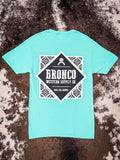 Full flat lay of bright teal Bronco tee showing back graphic with southwestern pattern