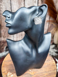 Western rectangle stud earring with raised floral tooling and beaded border displayed on mannequin