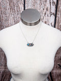Three-stone southwestern necklace with turquoise and jasper on silver chain displayed on mannequin