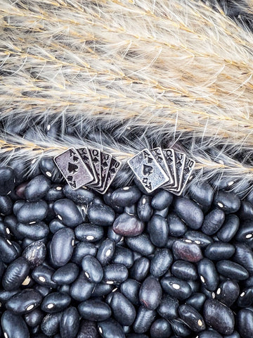 Stud earrings displayed on beans and wheat