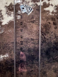 Stud earring shown on ruler for size