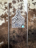Dangle earring on a ruler for size