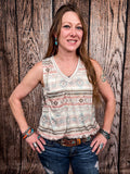 Model wearing tank top standing in front of a wood background.