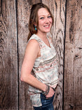 Model wearing tank top standing in front of a wood background.
