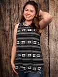 Model wearing tank top standing in front of a wood background.