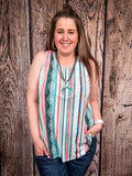 Model in front of a wood background wearing the Sunstripe Serape Tank Top styled with a necklace.