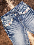 Angled view to show off the embroidered details along the front pocket of the jeans.