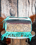 fanny pack on wood table, feathers and wheat in background
