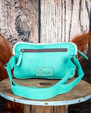 back of fanny pack on wood table, feathers and wheat in background