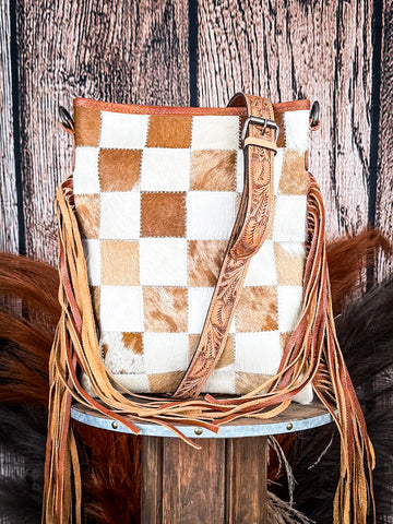 bag on wood table, feathers and wheat in background, wood backdrop