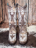 front of boots on cowhide, wood backdrop