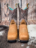 front of boots on cowhide, wood backdrop