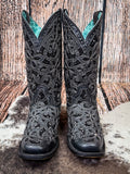 front of boots on cowhide, wood backdrop