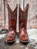 front of boots on cowhide, wood backdrop