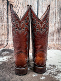 back of boots on cowhide, wood backdrop