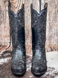 front of boots on cowhide, wood backdrop