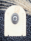 Earrings displayed on measurement board.