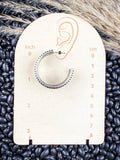 Earrings displayed on measurement board.