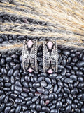Earrings displayed on wheat and beans.