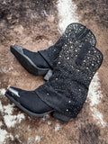 Flat lay of Stardust Glitter Bootie in Black By Very G on cowhide.