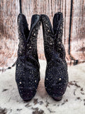 Back view of the Stardust Glitter Bootie in Black By Very G on a wood backdrop.