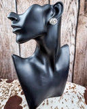 Trailblazer Concho Fashion Stud circle earring on a mannequin, sitting on cowhide, wood back drop. 