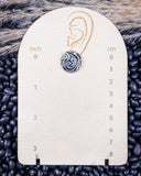 Trailblazer Concho Fashion Stud circle earring on a ruler, displayed on beans and wheat.