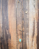 Arrow Rock Trail Fashion Necklace shown on a ruler, wood back drop. 